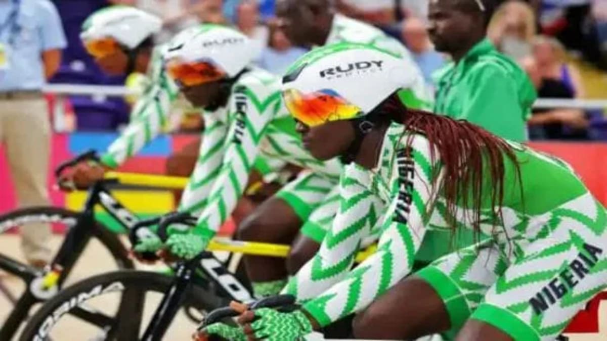 Nigerian cyclists celebrating with medals at packed velodrome in Abuja during African Championships