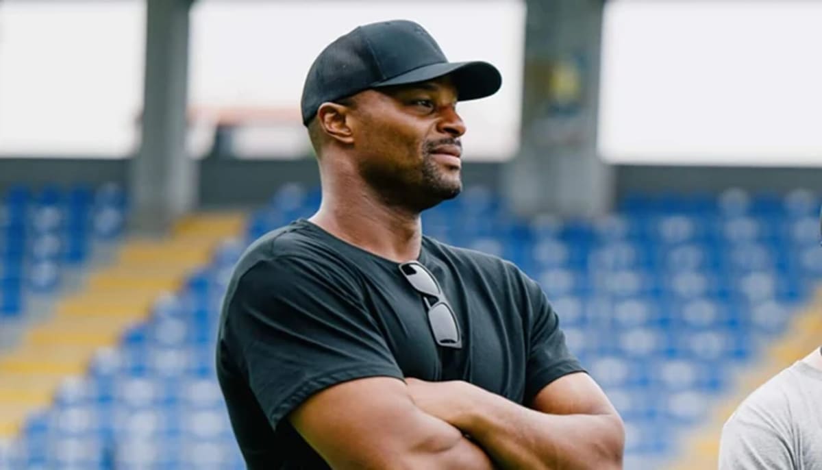 Osi Umenyiora in NFL Africa gear coaching young African athletes on football field