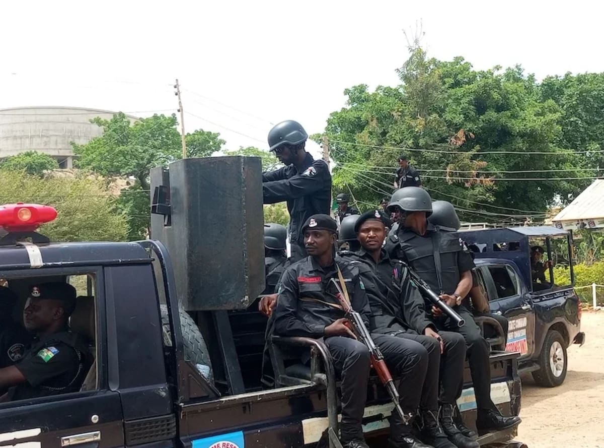 Police officers and community volunteers conducting nighttime security operation in Nigerian community