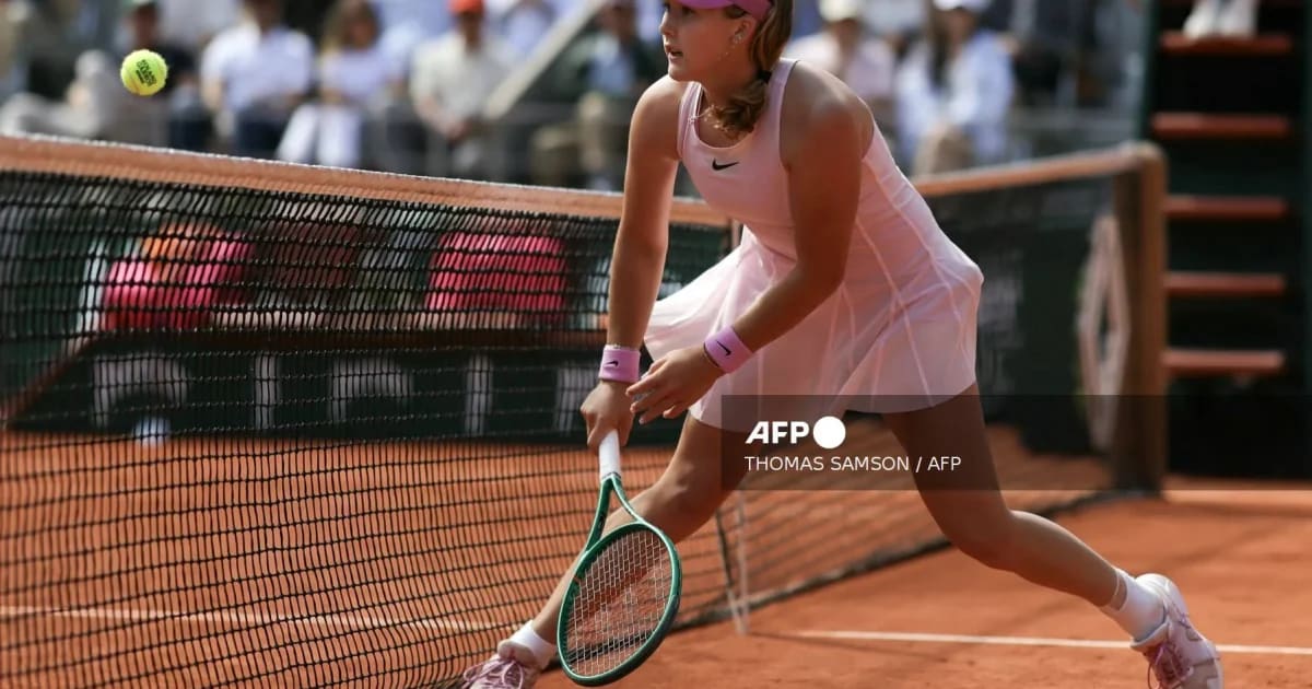 Mirra Andreeva celebrating on her knees after winning French Open championship point