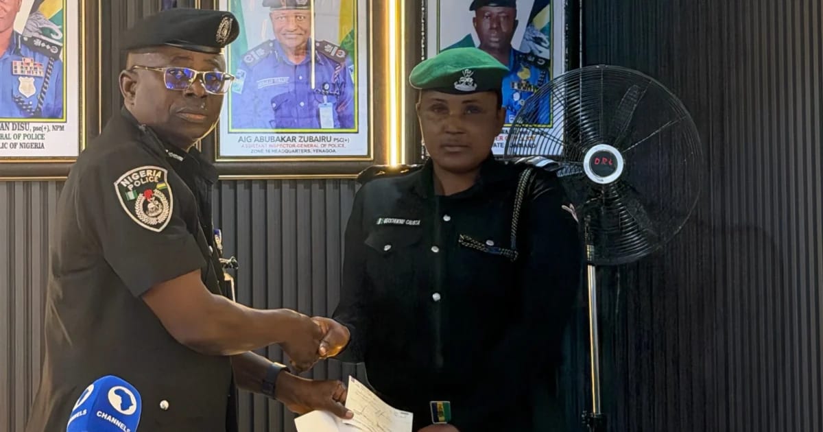 Nigerian police commissioner presenting ceremonial checks to families of fallen officers in Bayelsa State
