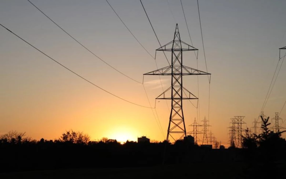 High-voltage electrical transmission towers and power lines against clear sky in Egypt