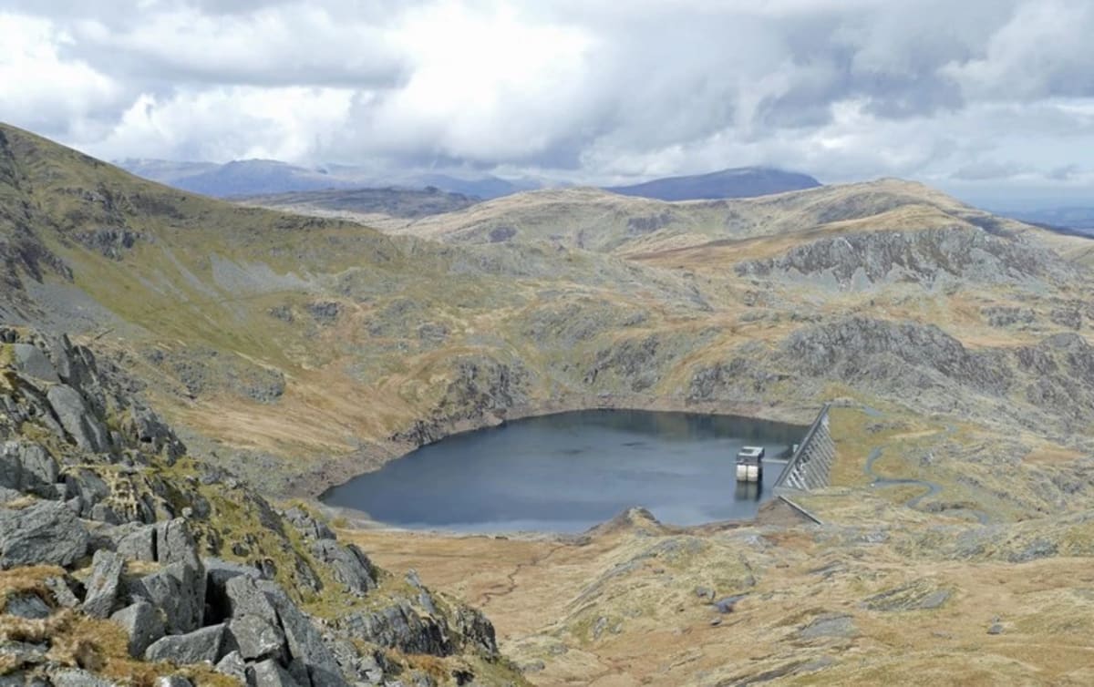 ** Hydroelectric dam in mountainous Norwegian landscape with reservoir and power infrastructure