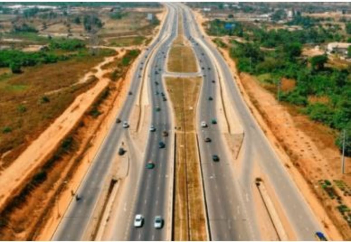 Aerial view of a modern highway construction project winding through green landscape in Nigeria