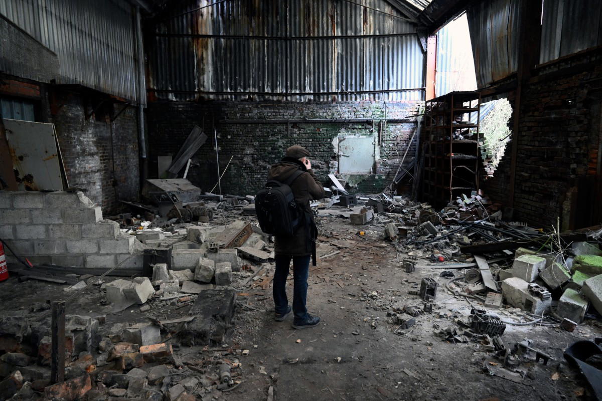 Urban explorer photographs abandoned steel plant warehouse in Charleroi Belgium with graffiti covered walls