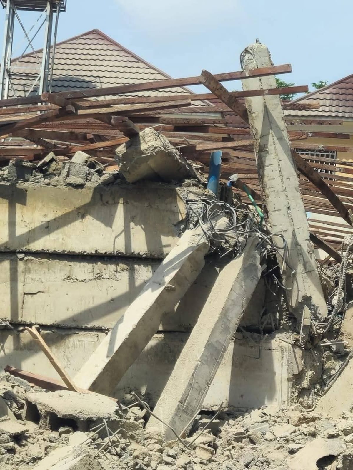 Rescue workers searching through concrete debris of collapsed three-story building in Abuja Nigeria