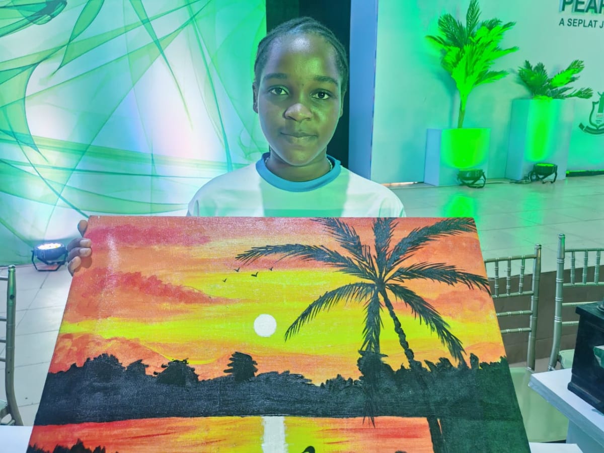 Nigerian teenage artist Favour Ochi standing beside her portrait drawings at exhibition