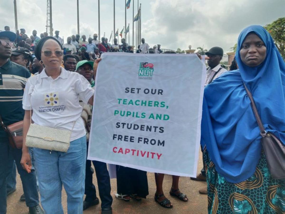 ** Nigerian teachers marching peacefully with signs during organized demonstration in Lagos