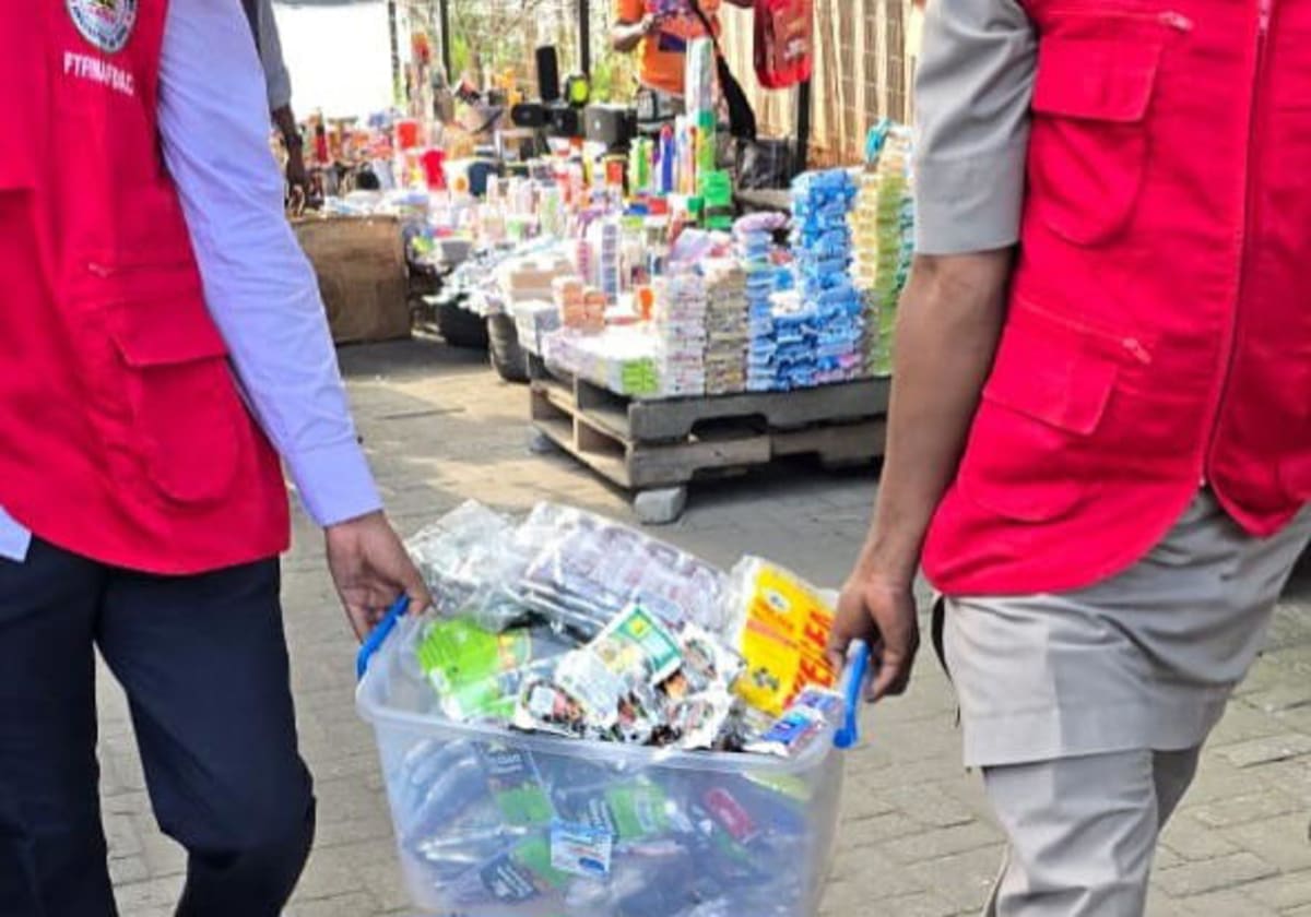 NAFDAC enforcement officers removing small alcohol sachets from store shelves in Nigeria