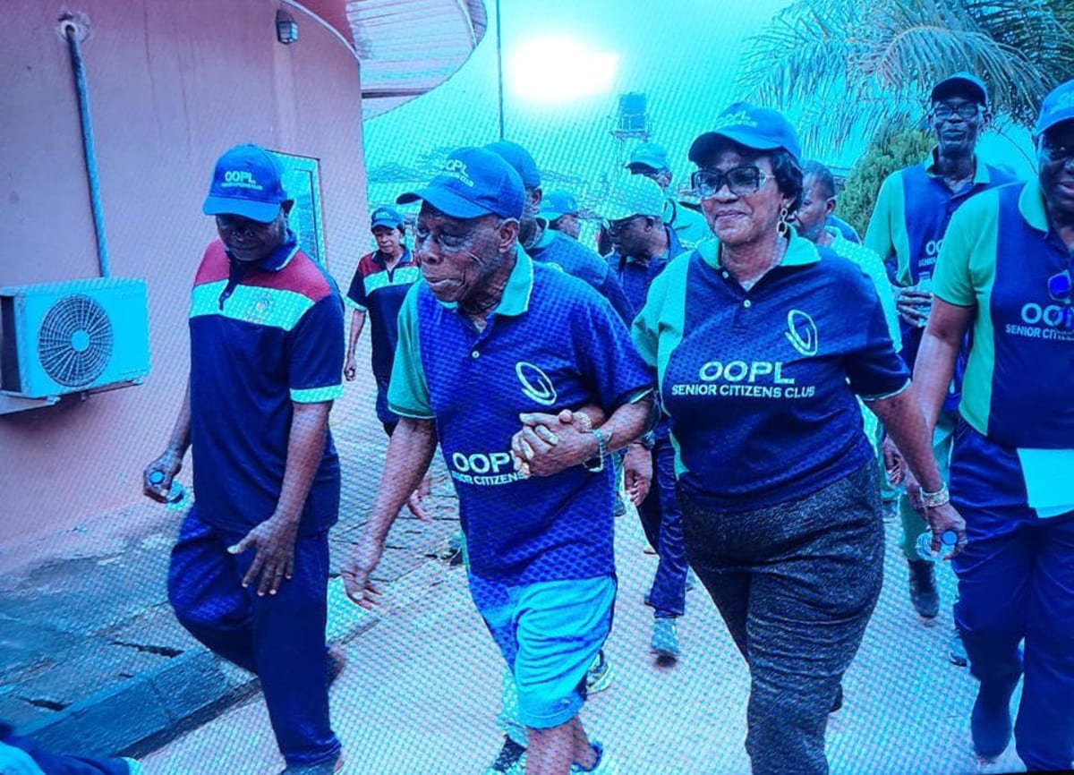 Group of senior citizens walking together outdoors in Abeokuta, Nigeria, led by former President Obasanjo