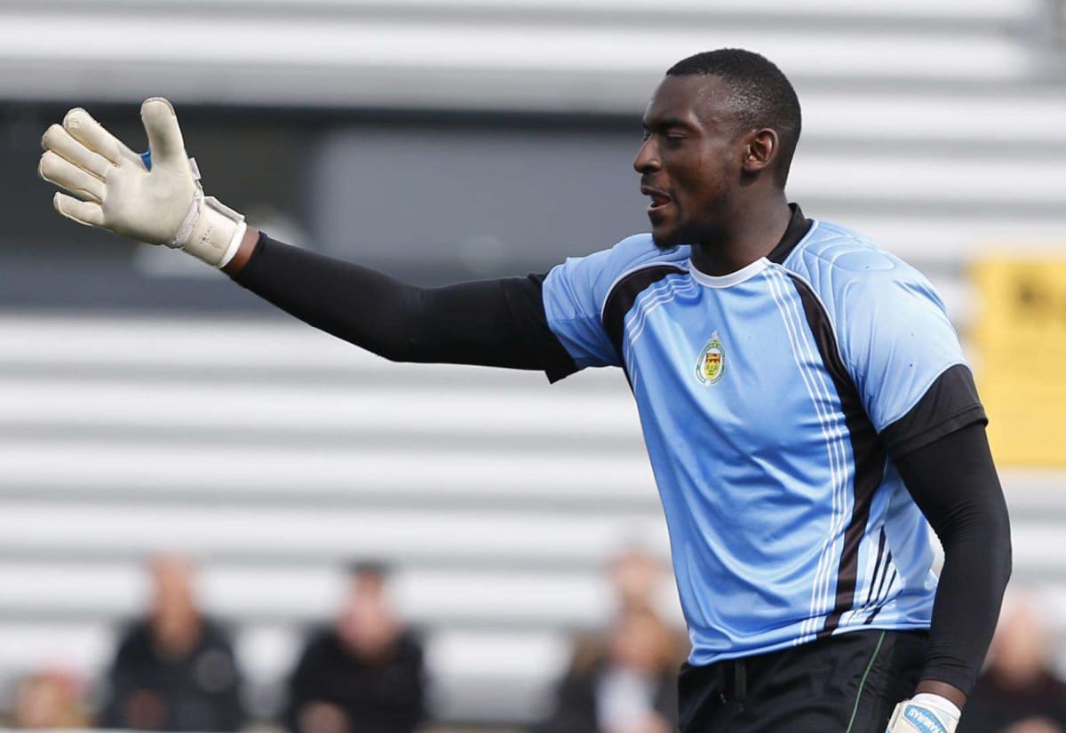 George Kamurasi in goalkeeper gear making a save during football match in London