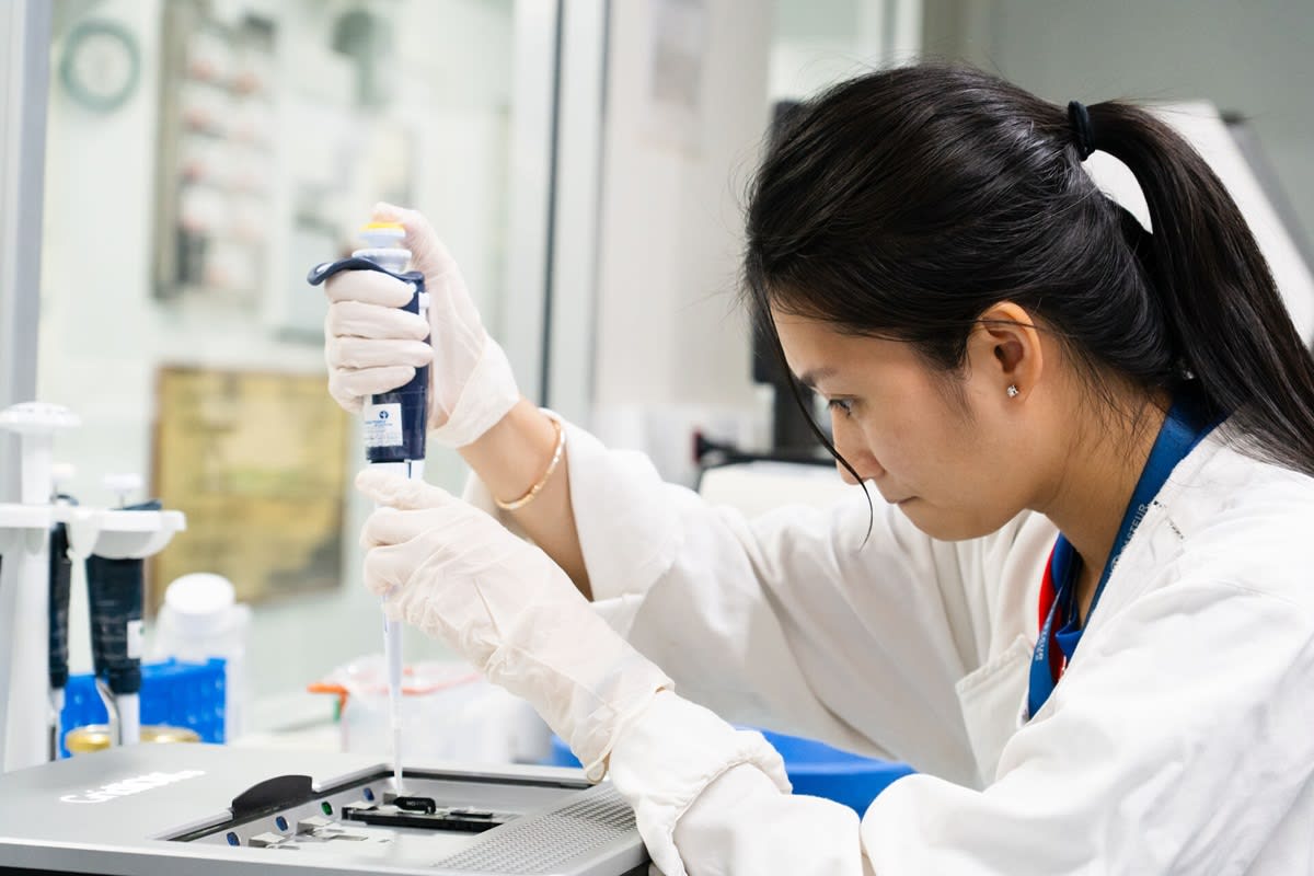 Diverse group of scientists collaborating around a table with global health technology displays
