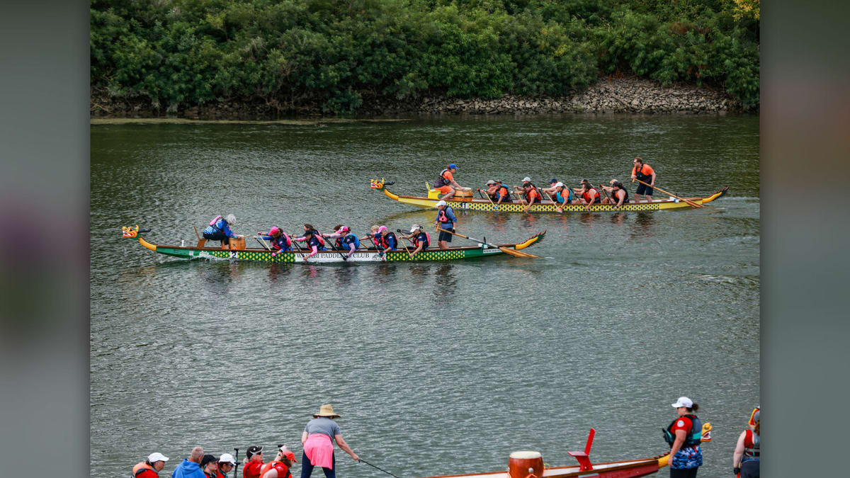 Dragon boat team of breast cancer survivors racing together on Lake River at Paddle for Life event