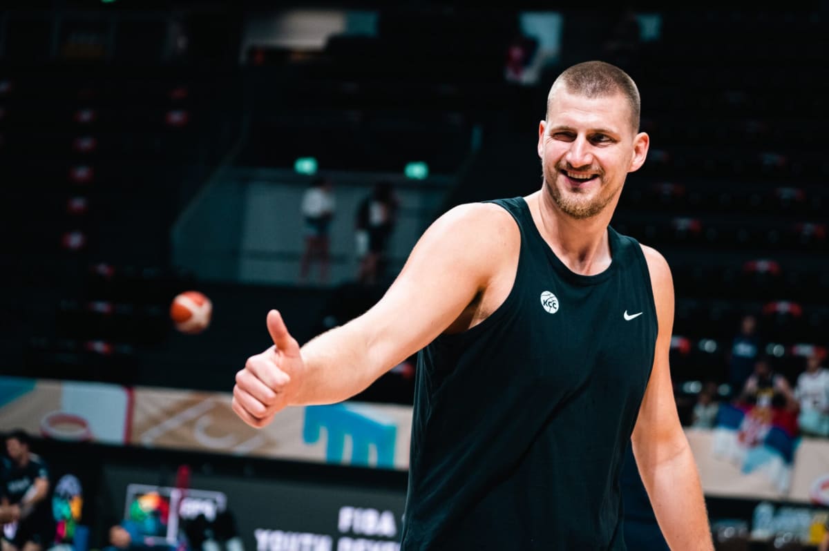 Nikola Jokic celebrating enthusiastically at a Serbian horse racing track surrounded by friends