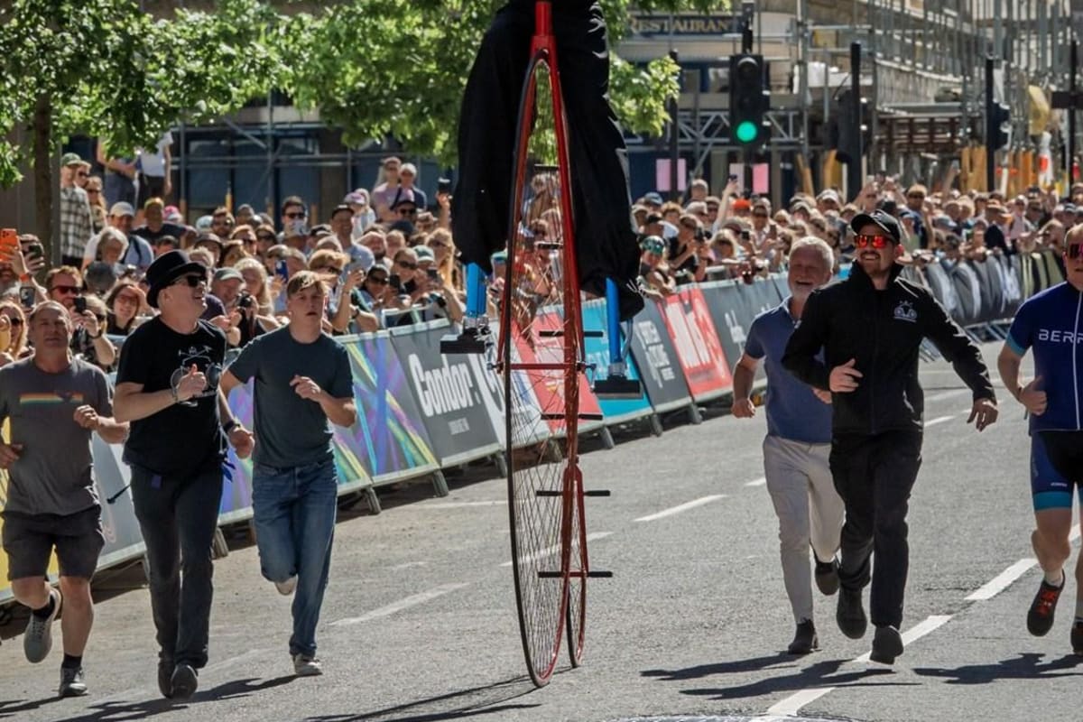 Man on stilts riding a giant 9-foot penny farthing bicycle at London cycling event
