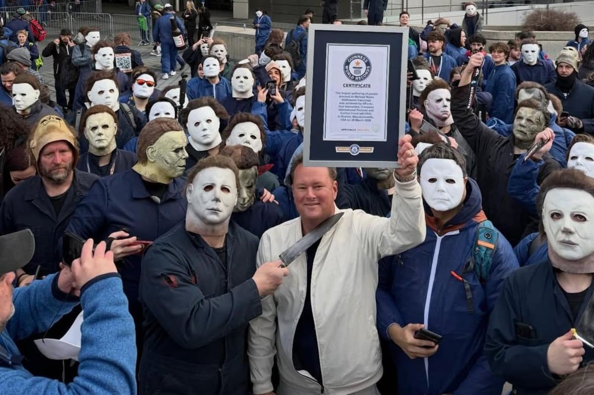 Large crowd of people wearing Michael Myers blue coveralls and white masks in Boston streets