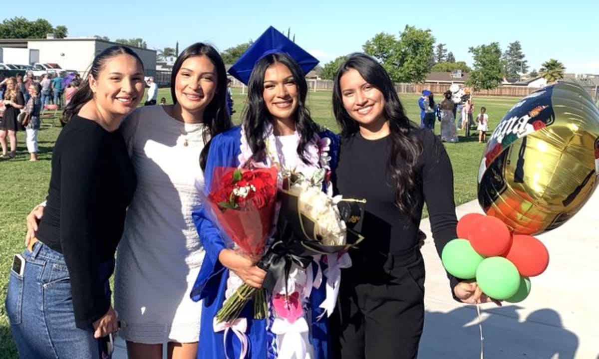 Graduating senior Kassandra Hernandez smiles with her sisters after Oakdale Charter School ceremony