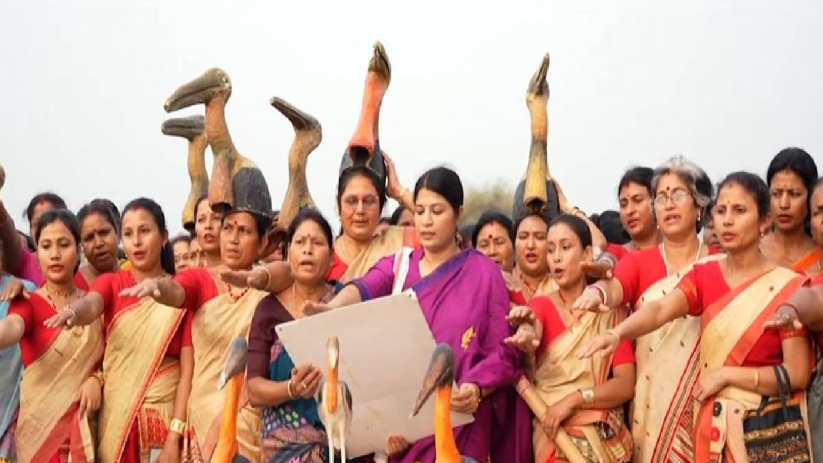 Women in traditional Indian dress standing near Greater Adjutant Stork nesting site in Assam