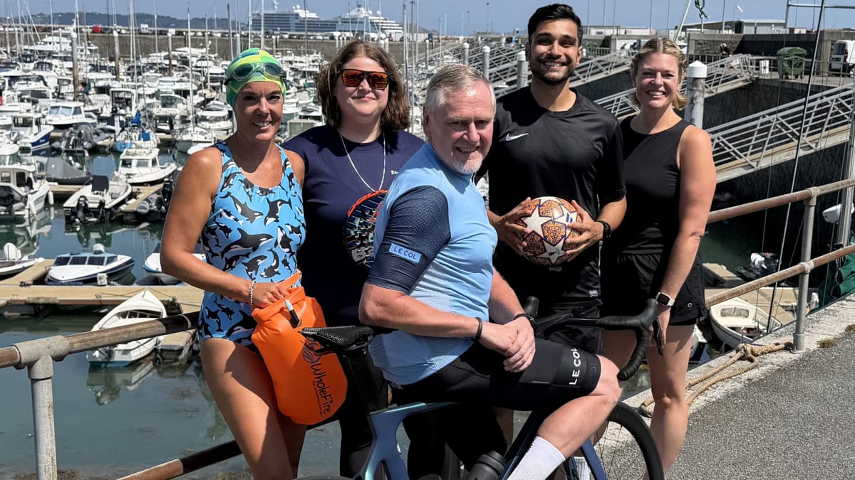 Five smiling Rothschild & Co employees standing together celebrating their charity fitness challenge victory