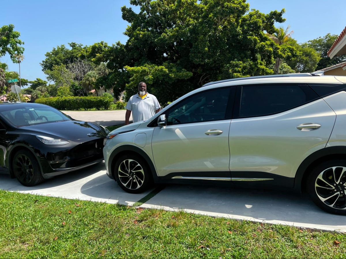 Electric vehicle plugged in charging at home overnight in residential driveway