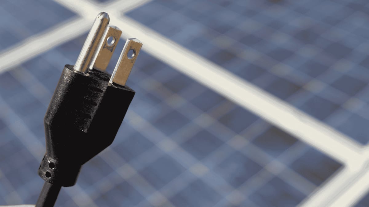 Large solar panel arrays stretching across open field with sunshine reflecting off panels