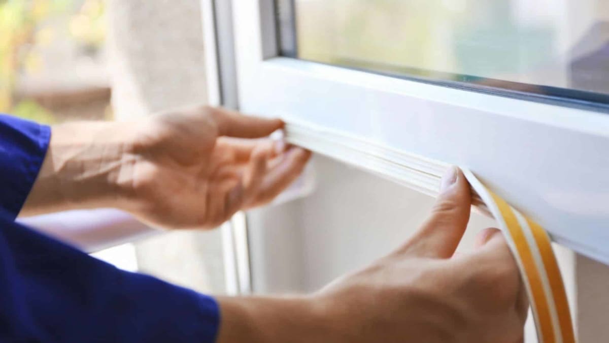Worker installing insulation in home wall to improve energy efficiency and safety
