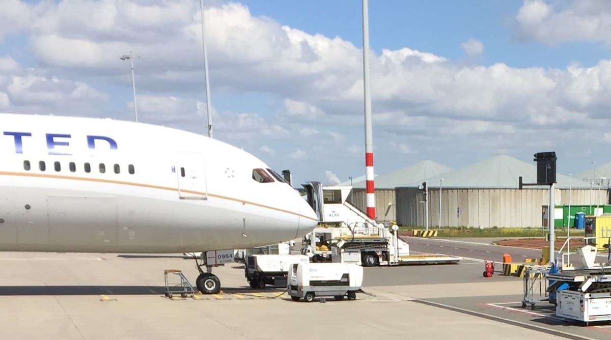 Commercial aircraft taking off from European airport runway against blue sky