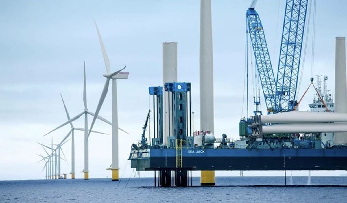 Offshore wind turbines standing in ocean waters generating renewable electricity for New England