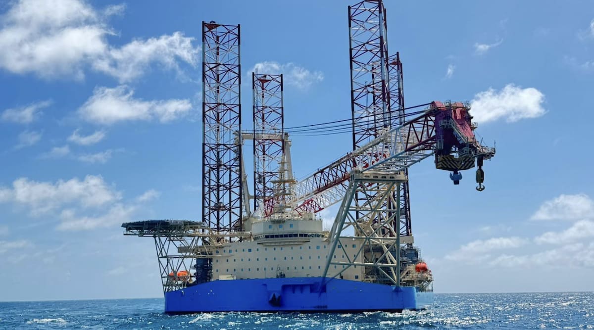 Massive offshore wind turbine installation vessel with tall crane approaching New York coast