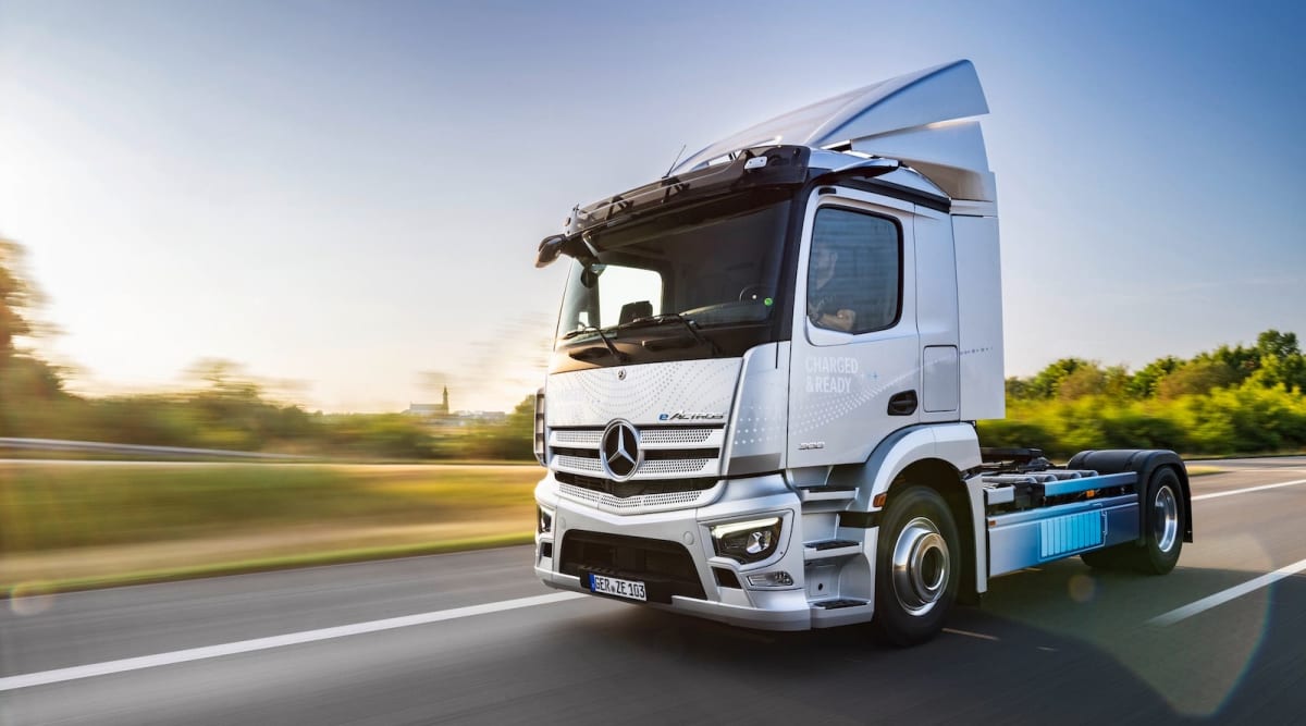 Electric truck charging at modern station alongside German highway infrastructure