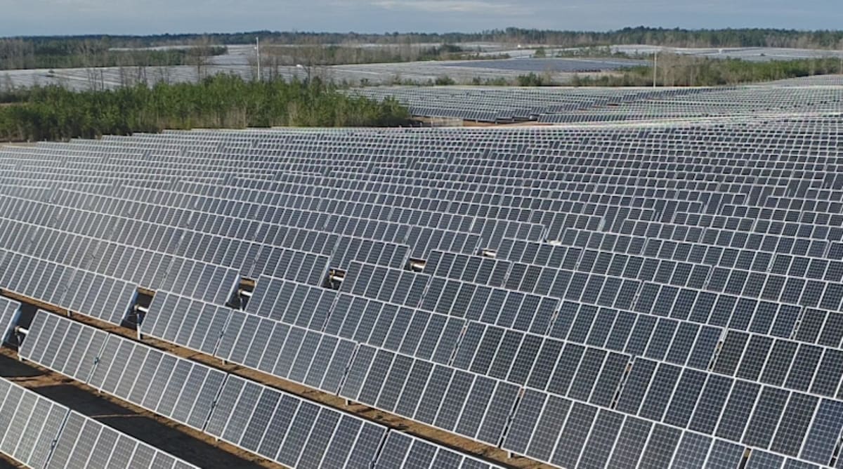 Solar panels stretching across Texas landscape under bright blue sky with sunlight