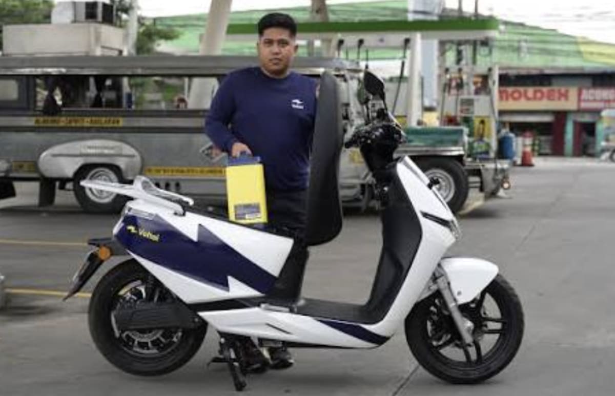 Electric delivery scooter with swappable battery system at charging station in Manila Philippines