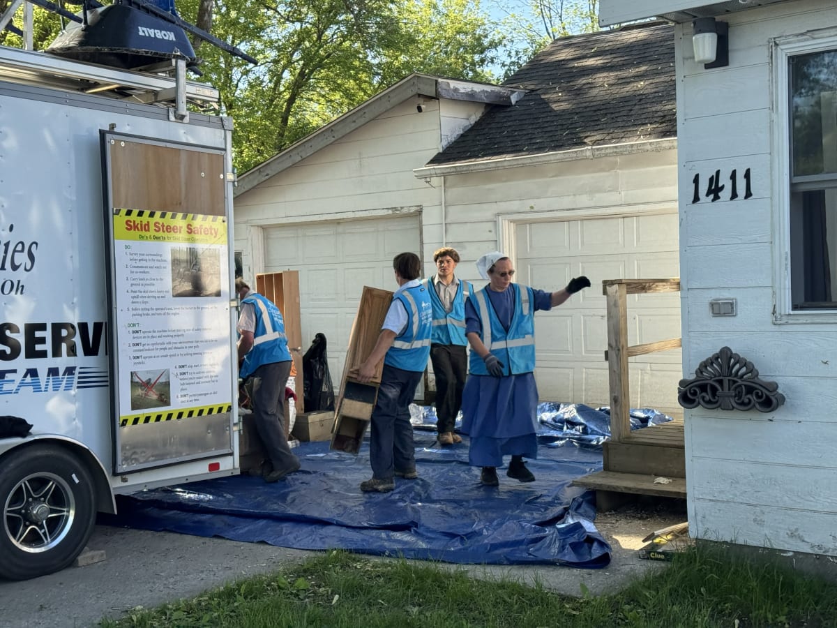 Volunteers working together on flood-damaged home repairs in residential neighborhood