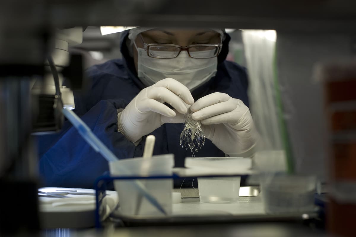 Medical device manufacturing worker assembling advanced stent graft components on production line