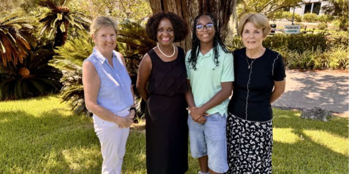 Aaron Lugo standing with Garden Club of Bermuda representatives holding scholarship award