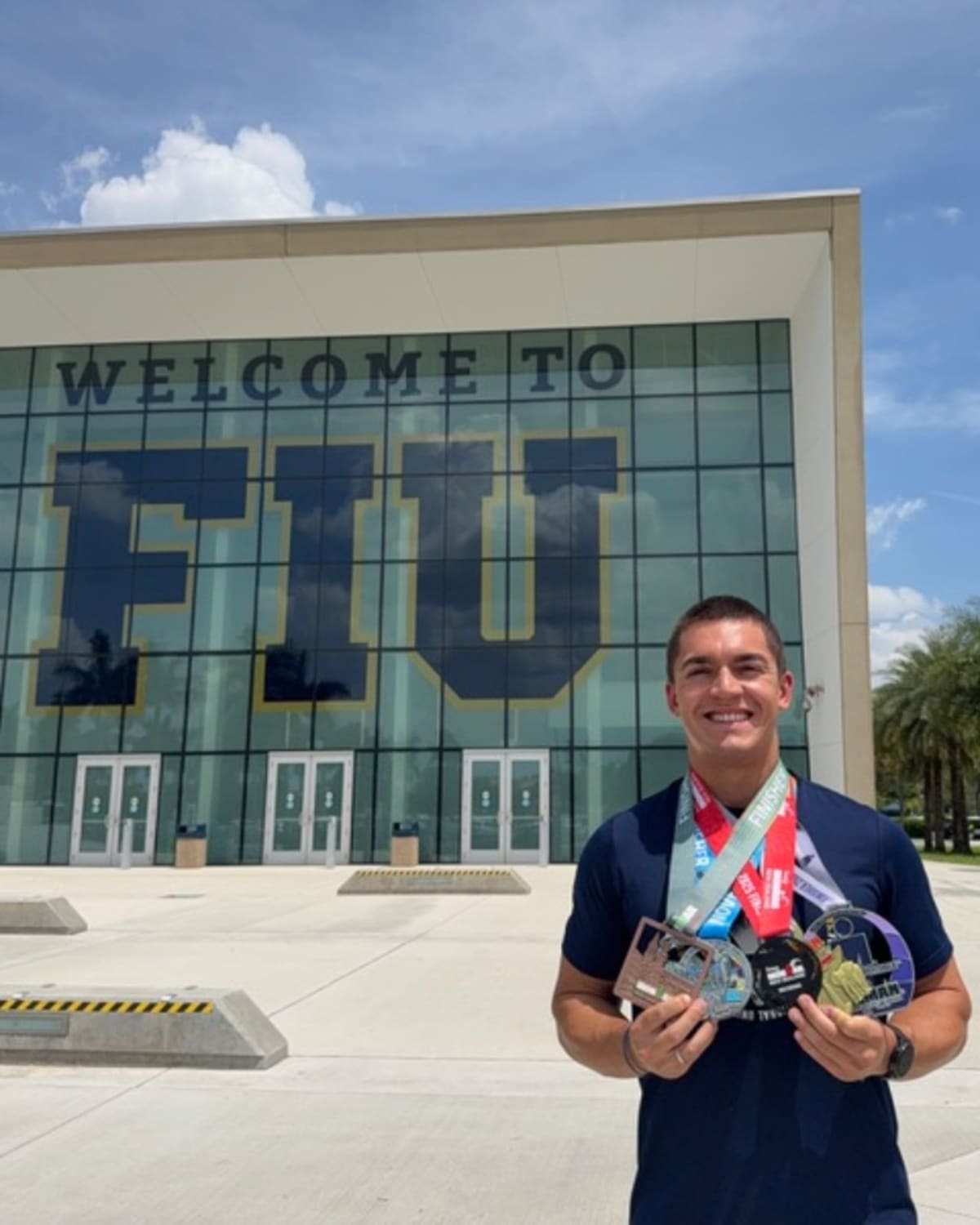 College student Giovanni Garotti crossing finish line at Ironman triathlon competition celebrating record