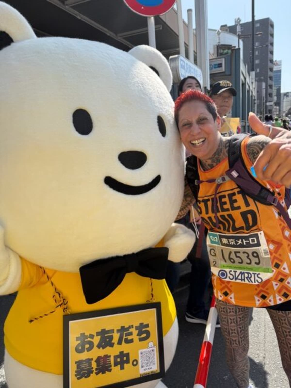 Runner Natasha Pollock celebrates after completing the Tokyo Marathon for charity Street Child