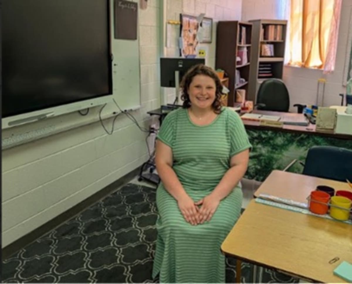 Sarah Emmer, young math and science teacher and breast cancer survivor, smiling in classroom