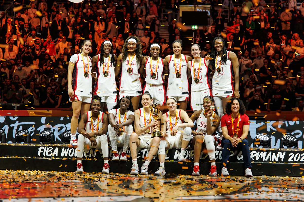 ** Team USA women's basketball players celebrating with gold medals and American flags at FIBA World Cup