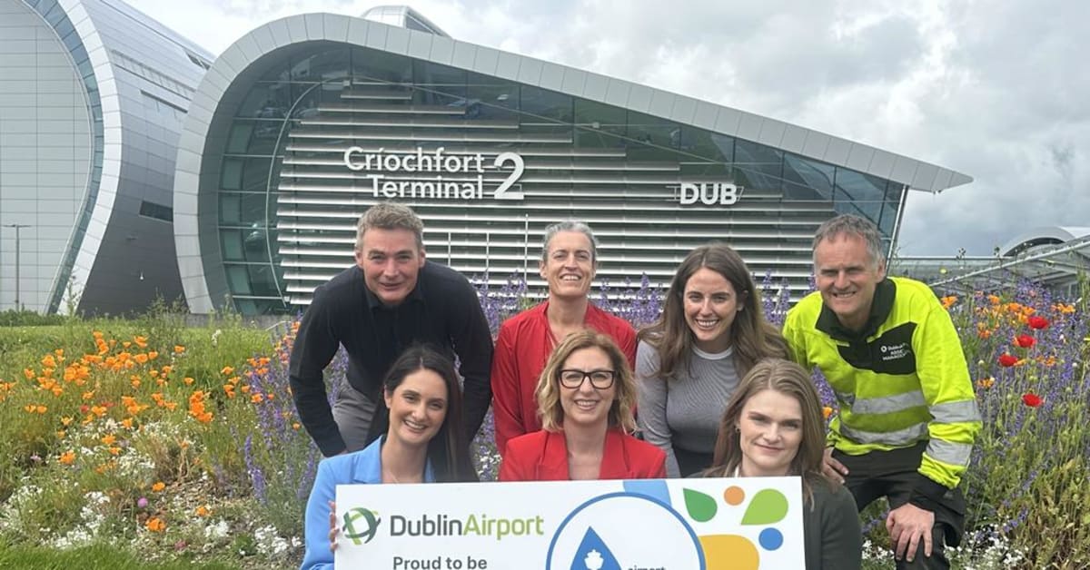 ** Dublin Airport terminal building exterior with aircraft on tarmac under clear skies
