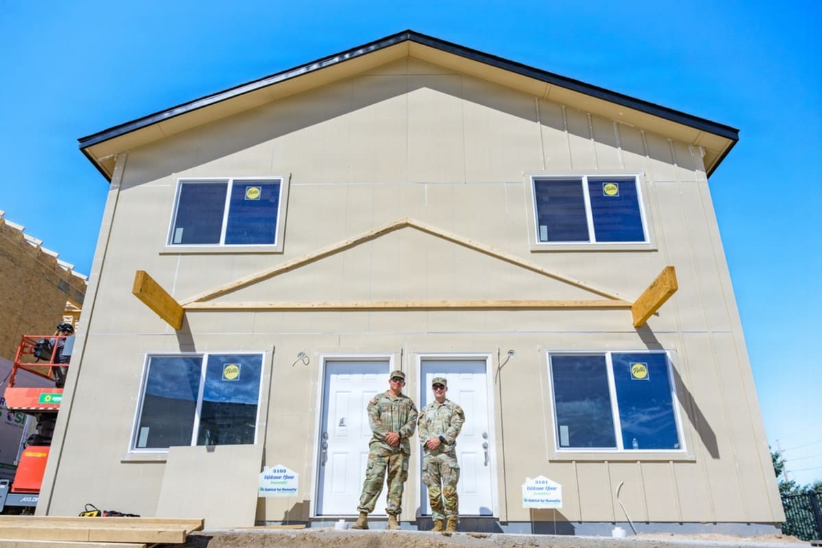 Wyoming Army National Guard soldiers and volunteers standing in front of newly constructed Habitat for Humanity homes