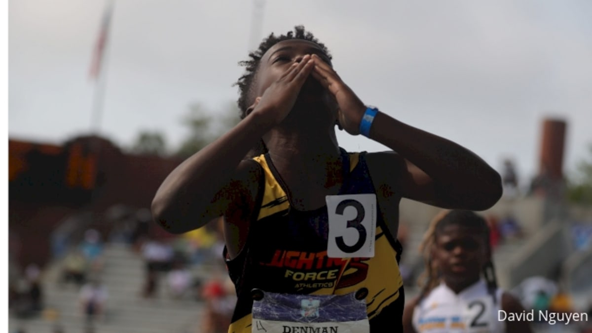 Two nine-year-old boys sprint neck and neck toward finish line at youth track meet