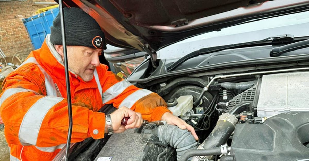** Railway maintenance worker performing hydrogen cleaning treatment on diesel train engine