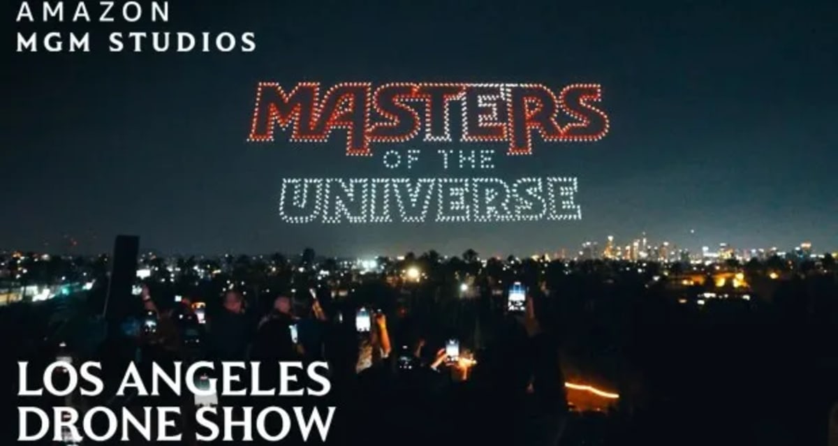 Bright illuminated drones forming characters in night sky over Los Angeles cityscape