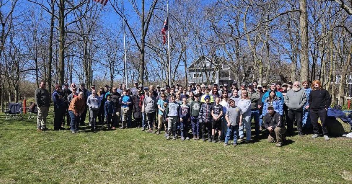 ** Volunteers in casual clothing clean up outdoor area at Johnson's Island historic site