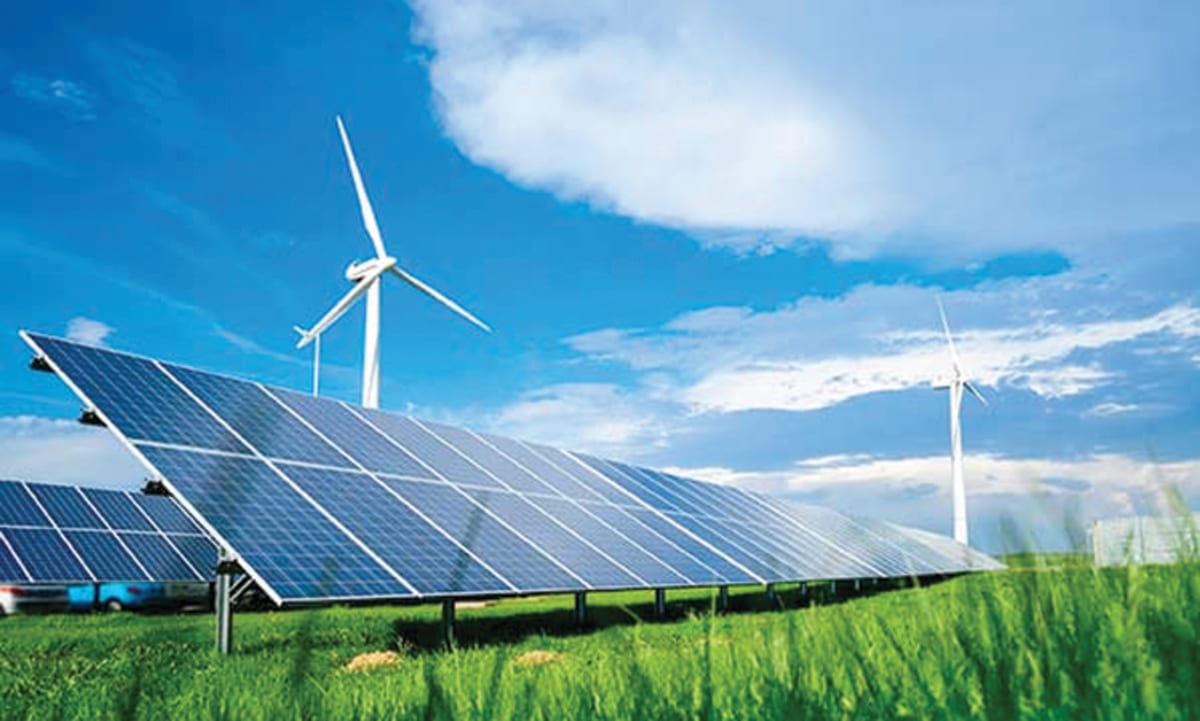 Solar panels and wind turbines stretching across landscape under bright blue sky