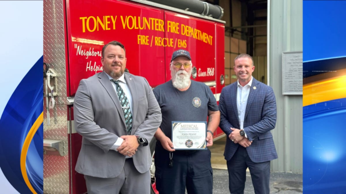 Volunteer firefighter in uniform receiving medical lifesaver award for saving choking toddler at restaurant