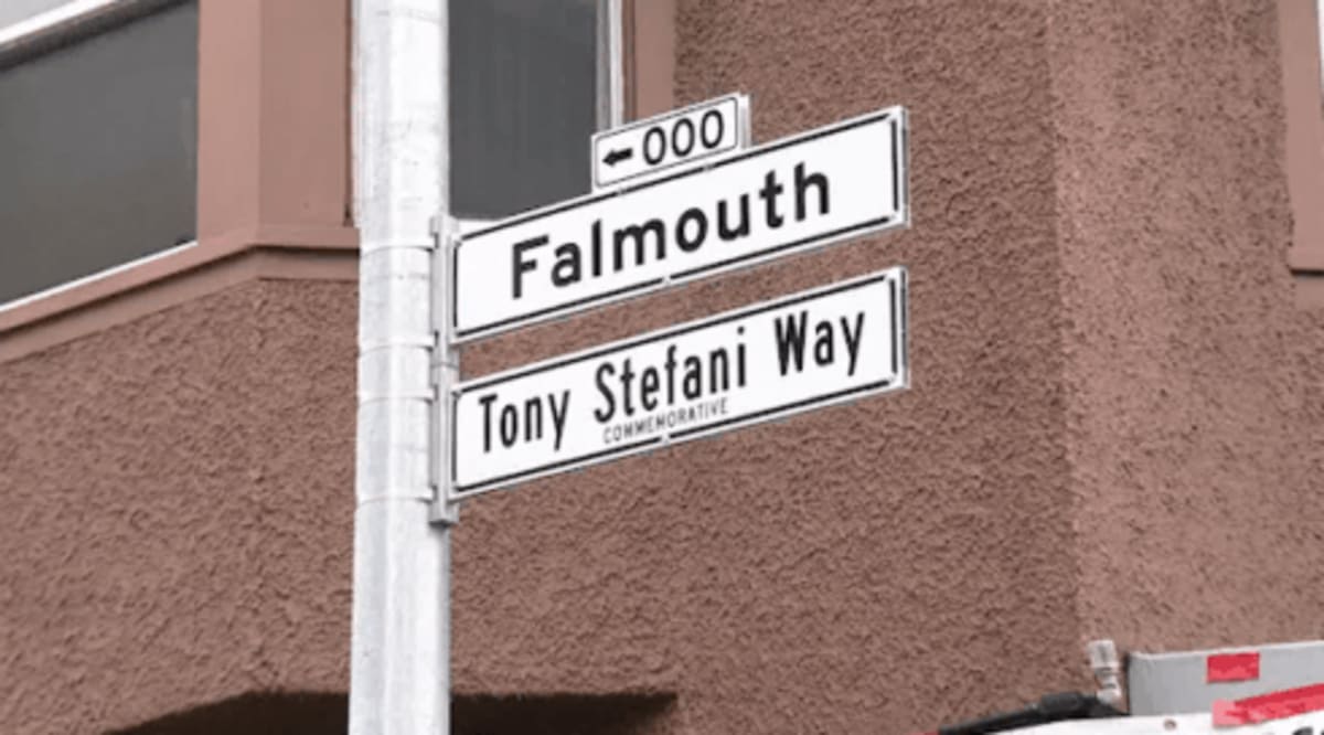 Retired Fire Captain Tony Stefani standing beneath newly renamed Tony Stefani Way street sign in San Francisco