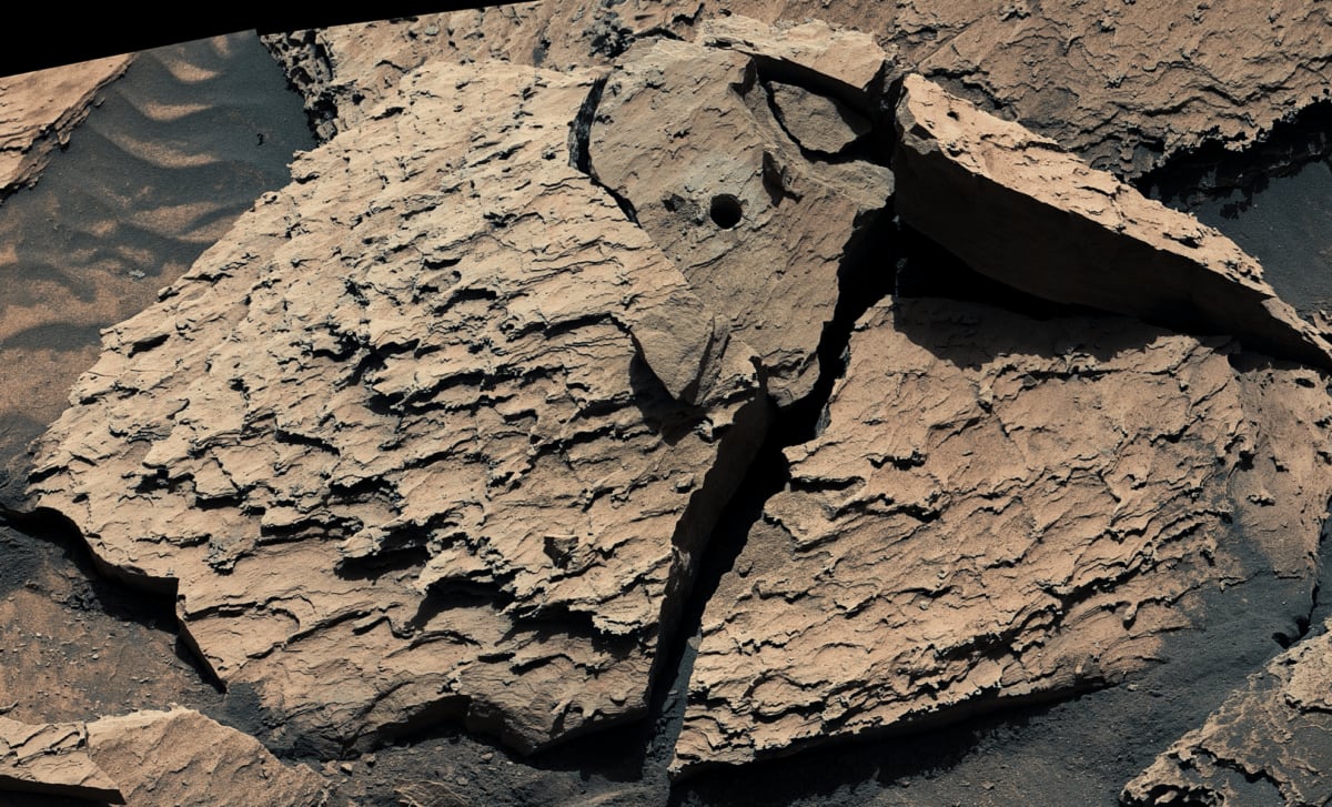 Mars rock Atacama with circular drill hole resting on red Martian surface captured by Curiosity rover