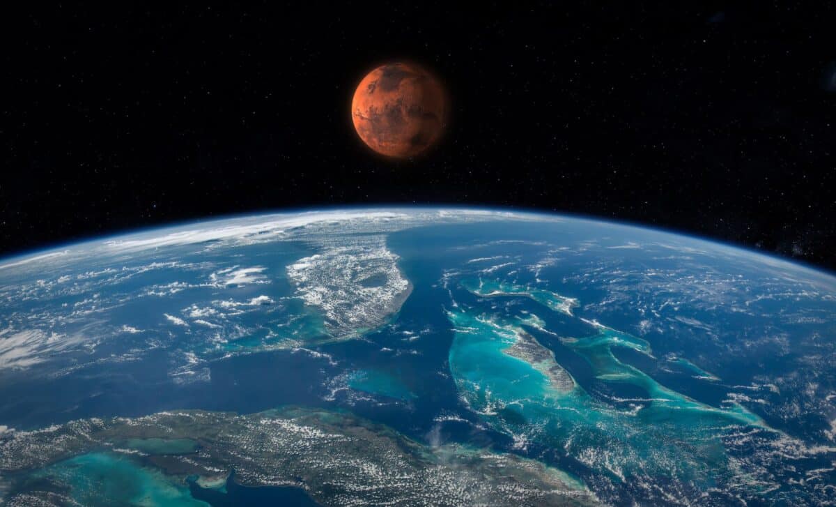 Illustration showing Earth and Mars side by side in space with cosmic dust particles surrounding them